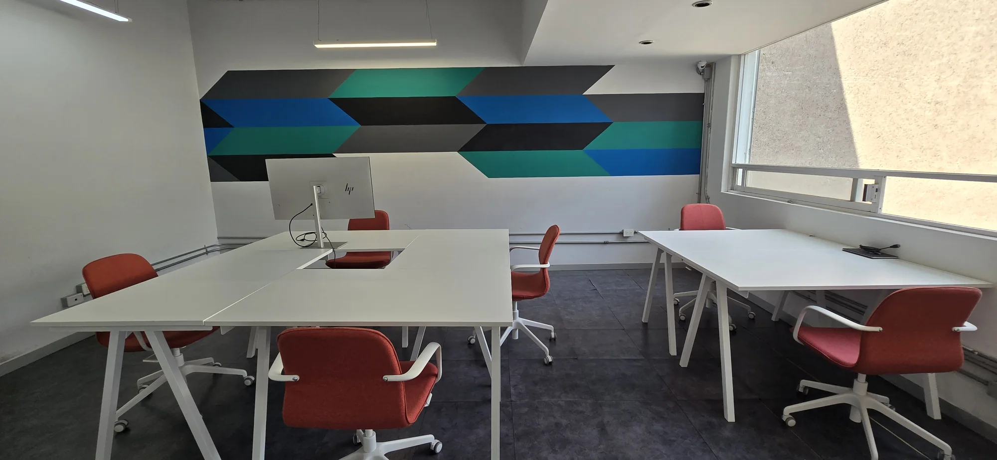 Open coworking floor with shared worktables.