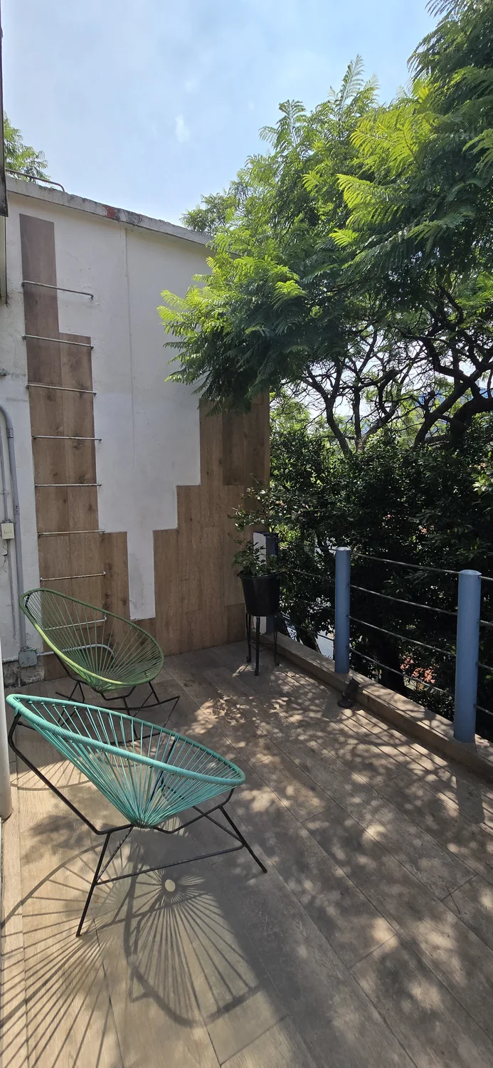 A quiet corner of the Interamerica Studios terrace among the trees.